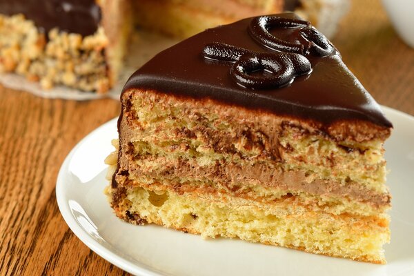 Morceau de gâteau dans un glaçage au chocolat sur une plaque