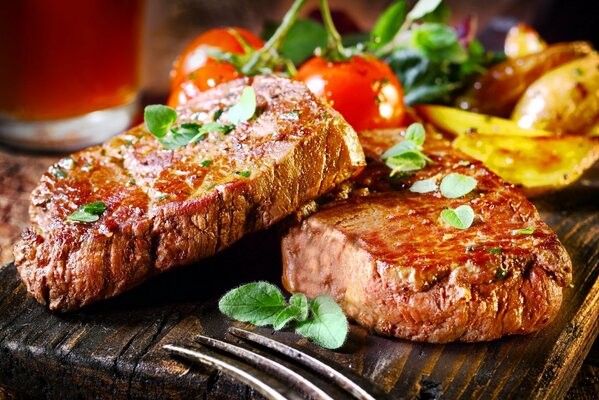 Trozos de carne jugosa con verduras en el tablero