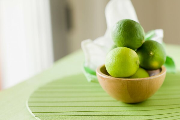 Citron vert dans une assiette sur un support vert