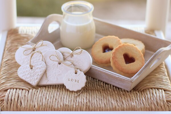 Milk and cookies on a tray, hearts decoration