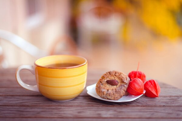 Gelbe Tasse Tee mit Mandelkeksen