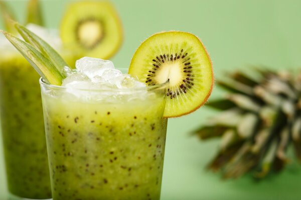 Kiwi cocktail with ice on a green background