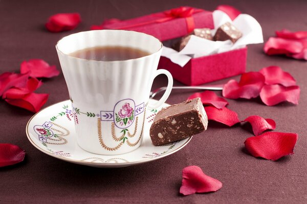 A cup of tea on the table with rose petals