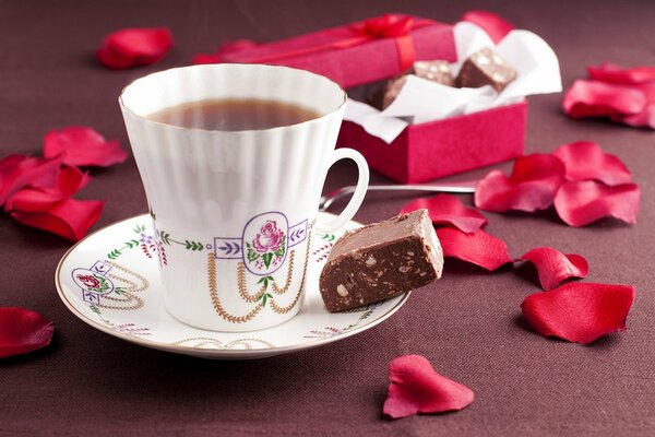 Tazza di tè sul tavolo con petali di rosa