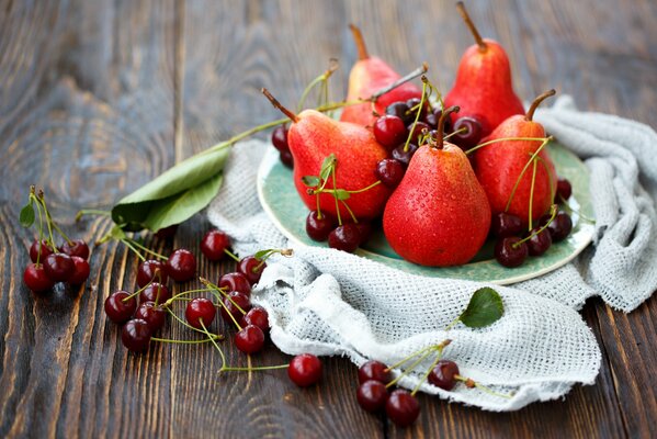 Still life of cherries and pears on a wooden background