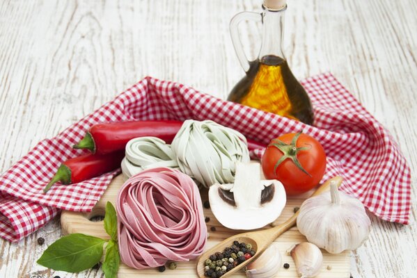 Pasta with mushrooms, tomatoes, pepper and garlic on a board