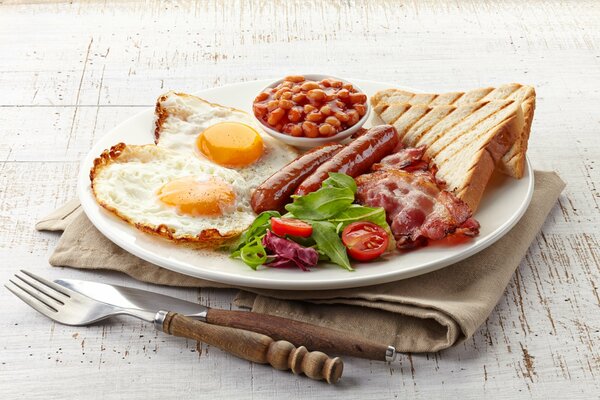 Leckeres Frühstück mit Bohnen, Toast, Speck und Rührei