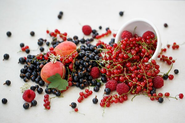 Berries are scattered on the table on a white tablecloth