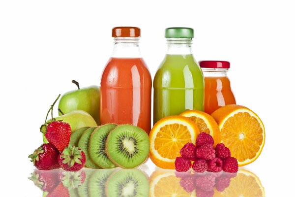 Jugos en botellas de vidrio y frutas