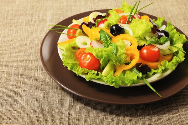 Hermosa ensalada brillante en un plato marrón