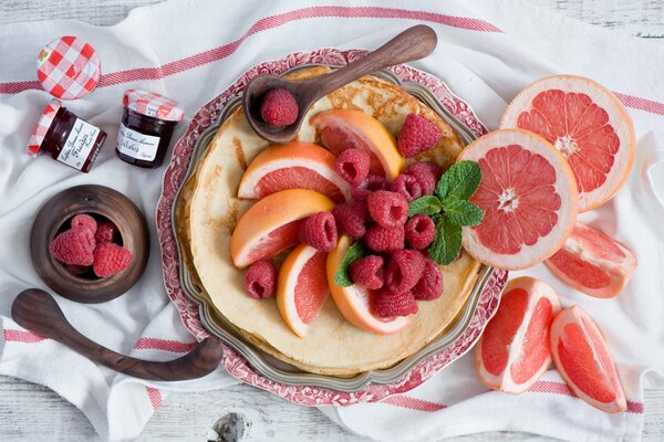 Pfannkuchen mit Himbeerbeeren und Grapefruit auf einem schönen Teller