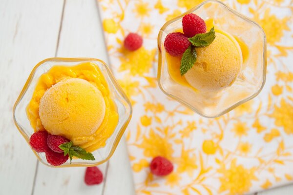 Yellow ice cream in a cream bowl with raspberries