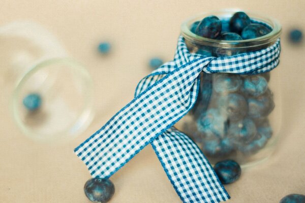 Blueberries in a transparent jar with a checkered ribbon