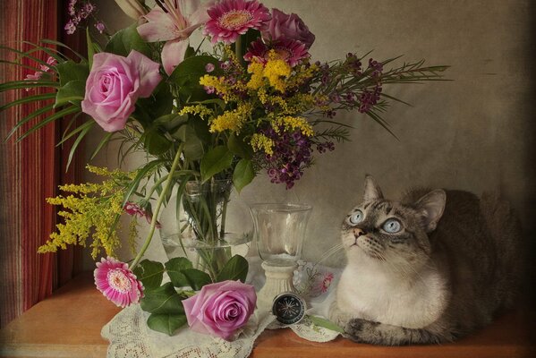 Cat on the background of a bouquet of roses