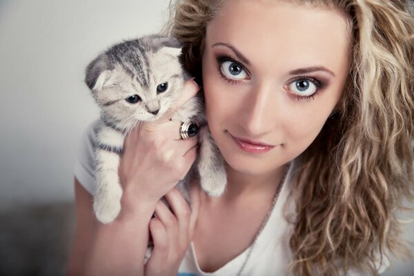 Curly-haired girl holds a small cat