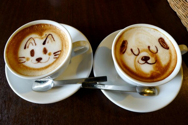 Due tazze di cappuccino e motivi sulla schiuma: gatto e cane soddisfatti