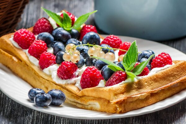 Kuchen auf einer Platte mit Beeren und Minze