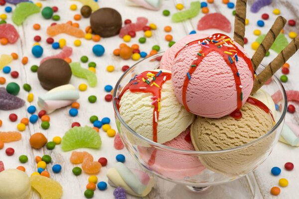 Dessert Eis in einem Glas auf dem Hintergrund von bunten Süßigkeiten