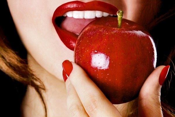 The girl s mouth bites a red apple