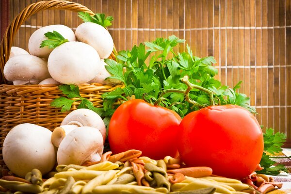 Cesta con champiñones y tomates al lado