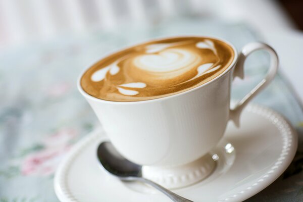 Patrón de capuchino en taza y platillo