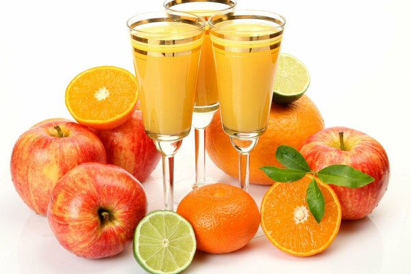 Orange juice in glasses with apples and oranges