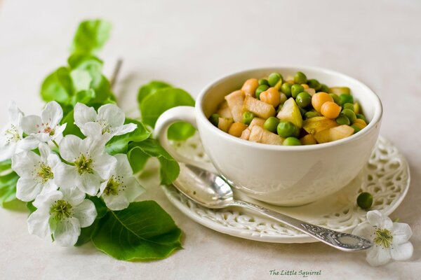 Salat in einer Tasse in der Nähe von Blumen