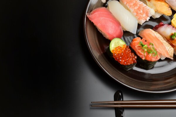Sushi z pałeczkami na czarnym tle