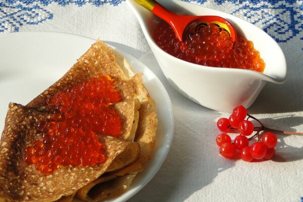 A plate of pancakes with red caviar