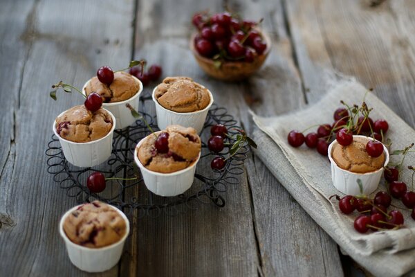 Piccoli cupcakes in tazze con ciliegie