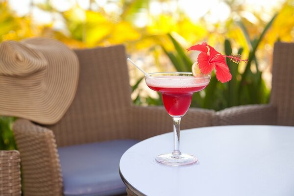 Cocktail with a flower and lemon on the table