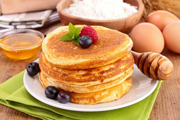 Rosige Pfannkuchen mit Beeren und Honig