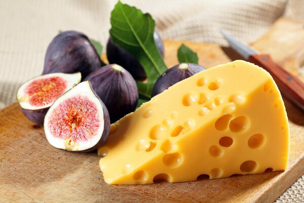 Fig fruits and a piece of cheese on the board