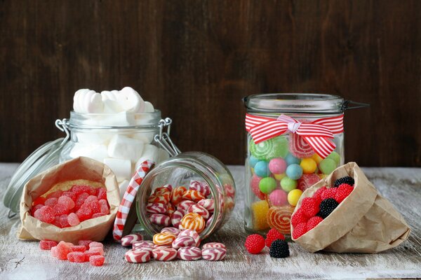 Bonbons et sucettes dans des bocaux sur la table