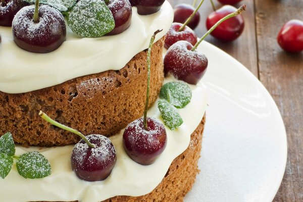 Gâteau éponge à la crème et aux cerises dans le sucre en poudre