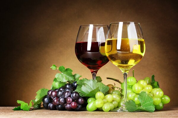 Vino blanco y tinto en copas con uvas