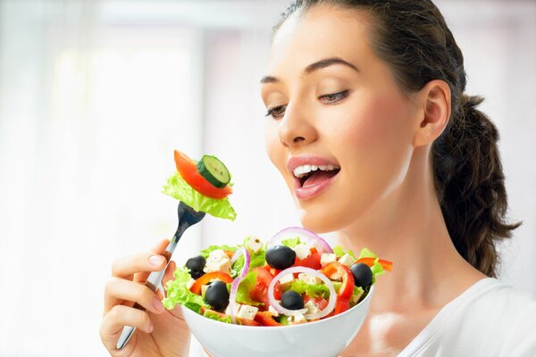 Charmante braunhaarige mit einem Teller Salat