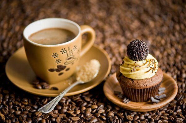 Auf dem Hintergrund der Kaffeebohnen steht eine Tasse Kaffee und Kuchen