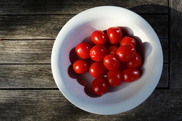 Red cherry tomatoes in a white plate