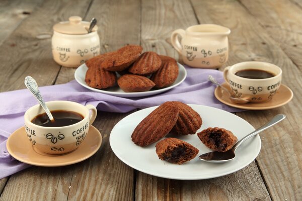 Café dans des tasses avec des biscuits Madeleine