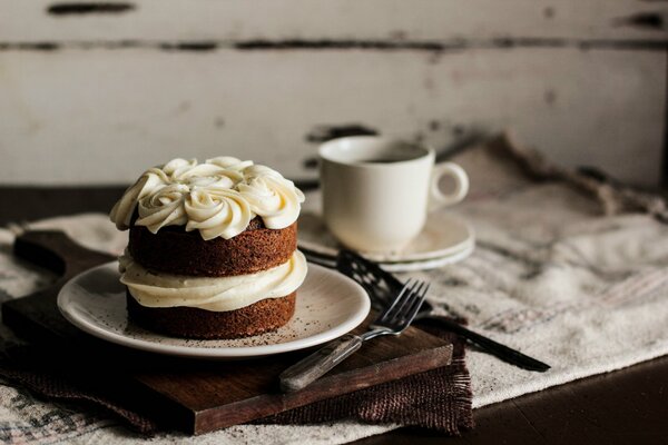 Biskuitkuchen mit Sahne und Tasse Kaffee