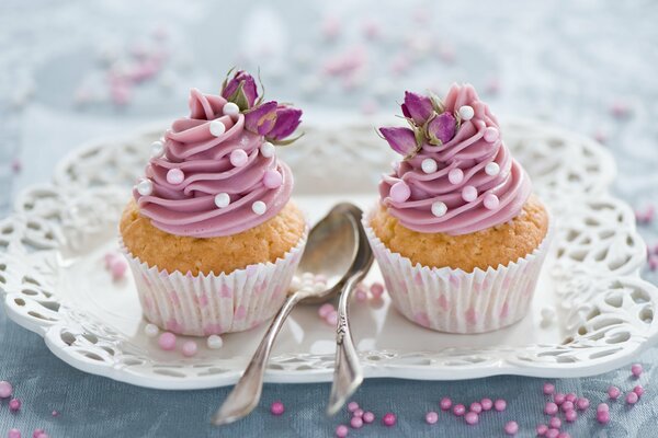 Dos cupcakes con decoración rosa en un plato