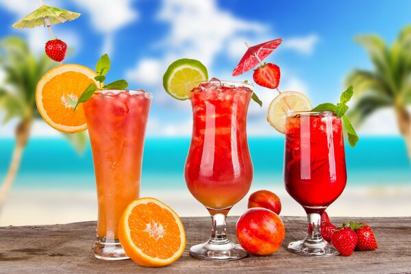 Trois cocktails avec des parasols de baies et de citron en été