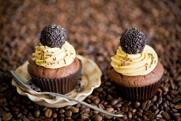 Cupcakes al cioccolato con crema su uno sfondo di chicchi di caffè