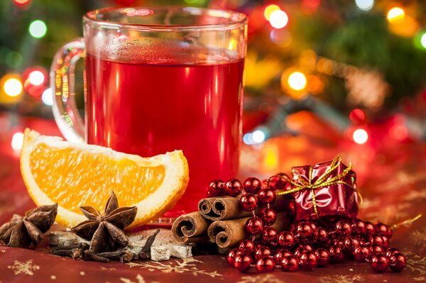 Glühwein auf Neujahrshintergrund mit saftiger Orange