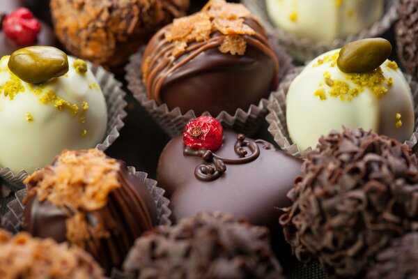 Dunkle Schokoladenbonbons sind mit Beeren und Pistazien verziert