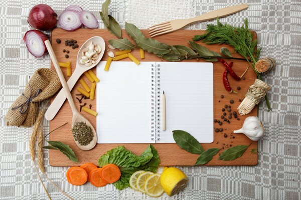 Notebook surrounded by greenery, vegetables and appliances
