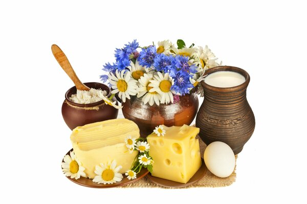 A pot of milk and cottage cheese next to a bouquet of wildflowers