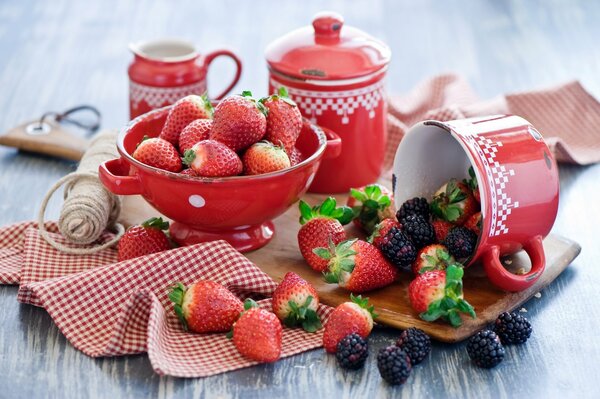 Still life of strawberries and red dishes