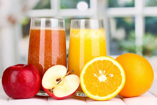 Fruit juices in orange and apple glasses